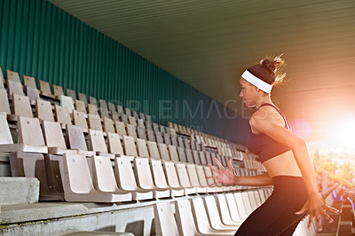Buy stock photo Shot of a young woman running up stairs in a sports stadium