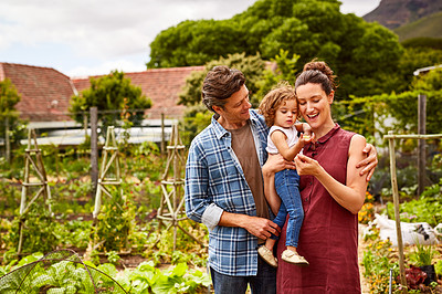 Buy stock photo Portrait of a couple with their little girl standing their organic garden