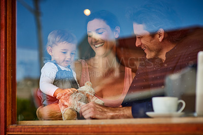 Buy stock photo Shot of a loving couple with their baby daughter sitting in a cafe