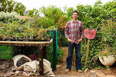 Buy stock photo Portrait of a mature man standing outside leaning on a community garden sign