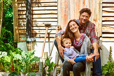 Buy stock photo Portrait of a couple with their baby girl sitting their organic garden