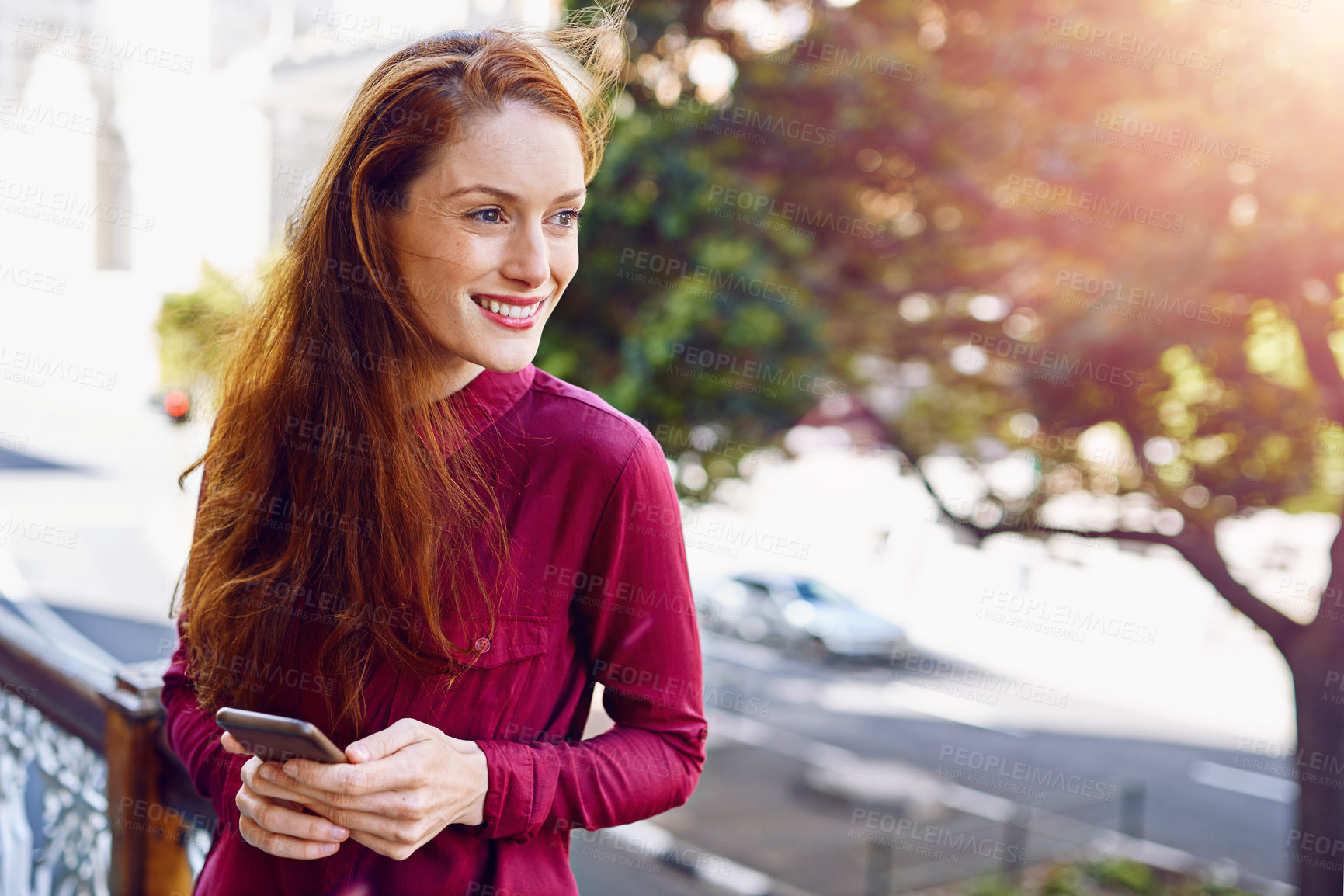 Buy stock photo Shot of a young woman sending a text message while standing outside