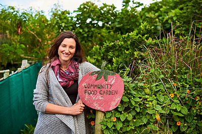Buy stock photo Portrait of a mature woman standing outside leaning on a community garden sign