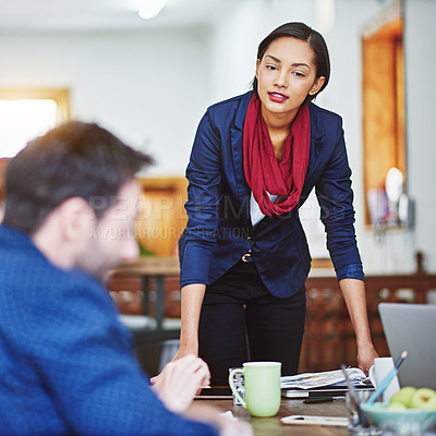 Buy stock photo Shot of a manager leaning on a table in an office during a meeting