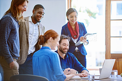 Buy stock photo Shot of a group of colleagues talking together over a laptop in an office