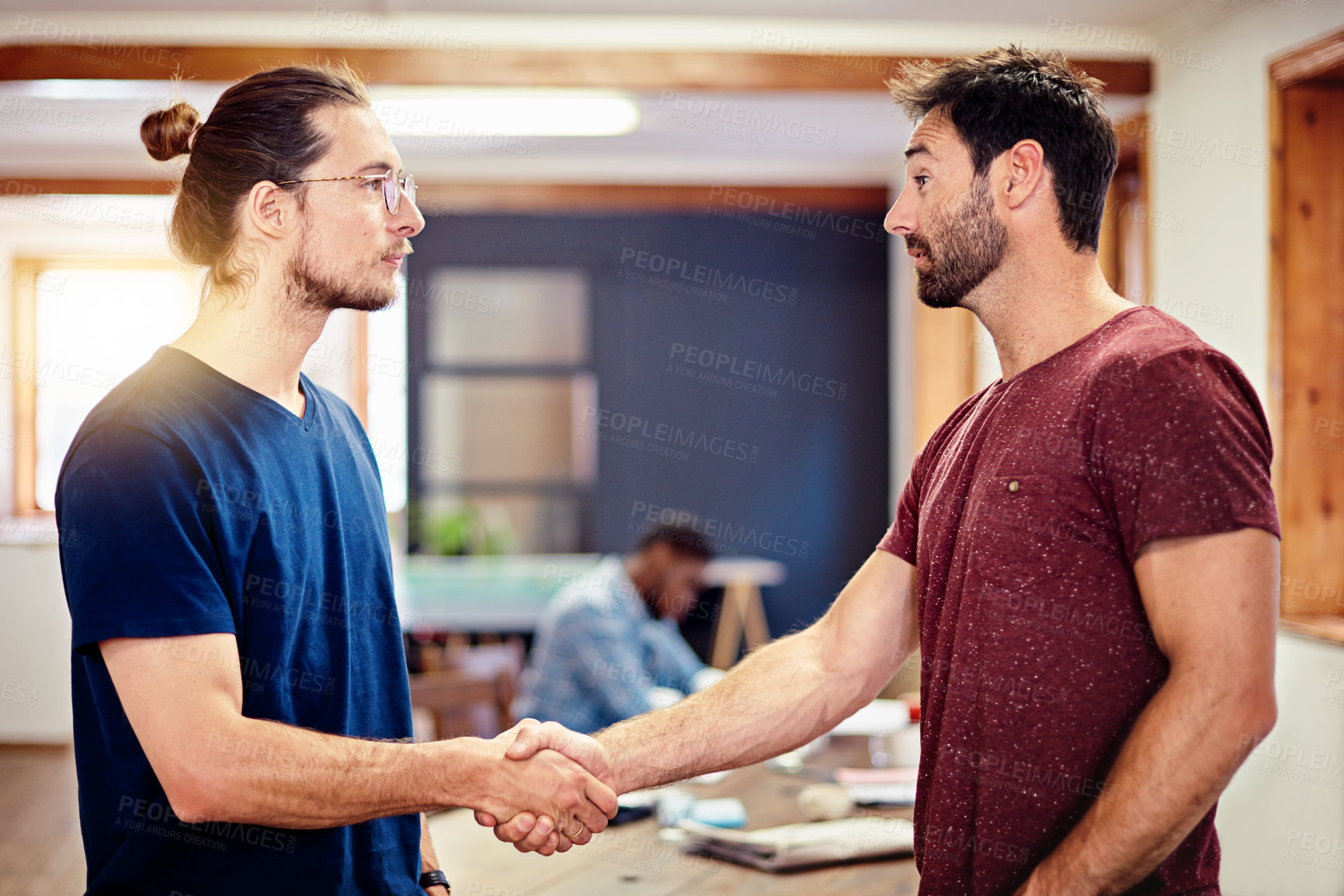 Buy stock photo Shot of two men shaking hands together in an office