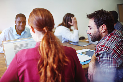 Buy stock photo Shot of a group of colleagues working together around a table in an office