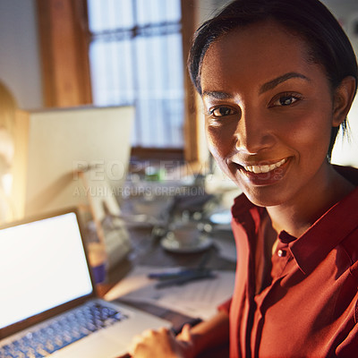 Buy stock photo Portrait of a smiling young woman working on a laptop in an office in the evening