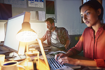 Buy stock photo Shot of a young woman working on a laptop in an office in the evening