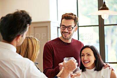 Buy stock photo Shot of two couples talking and toasting together while enjoying a get-together at home