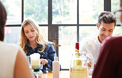 Buy stock photo Shot of a group of friends enjoying a home-cooked dinner together