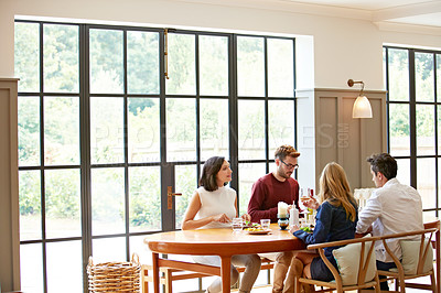 Buy stock photo Shot of a group of friends enjoying a home-cooked dinner together