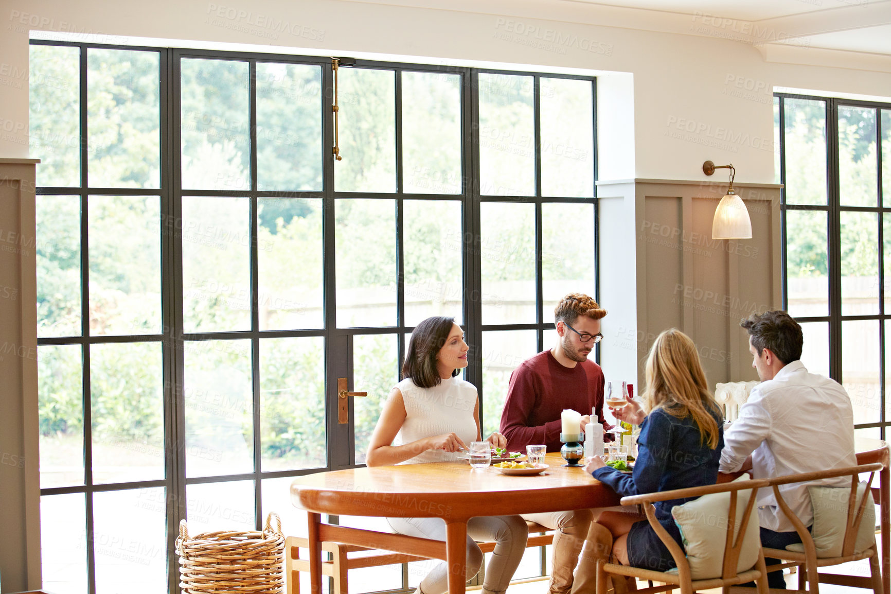 Buy stock photo Shot of a group of friends enjoying a home-cooked dinner together