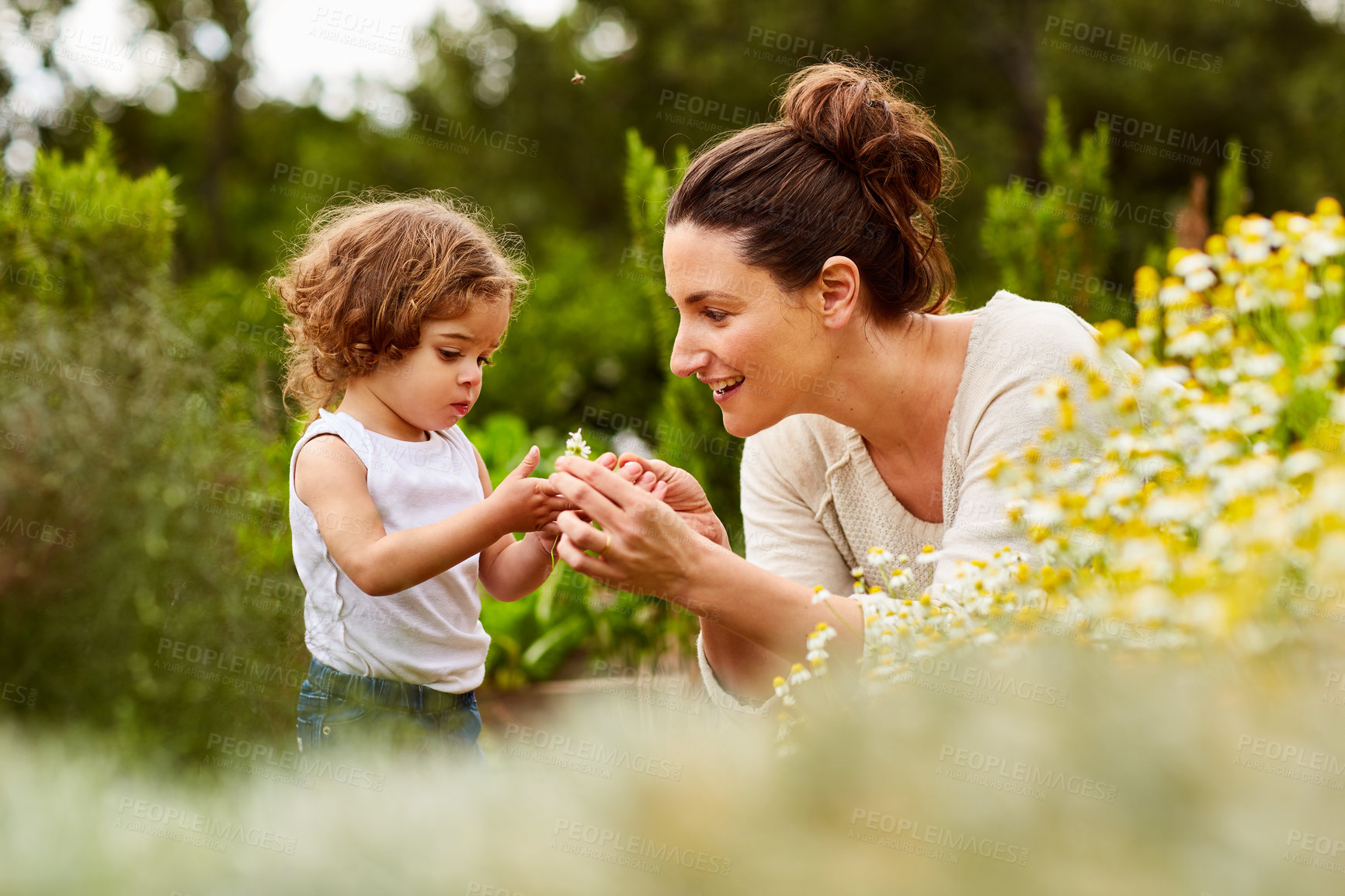 Buy stock photo Shot of a mother and little daughter looking at plants in an organic garden