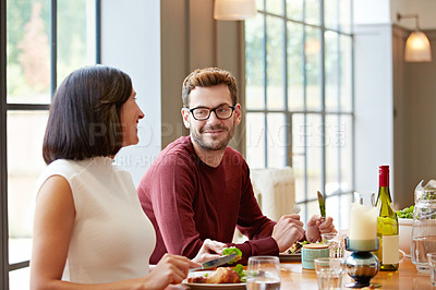 Buy stock photo Shot of a young couple enjoying a home-cooked dinner together
