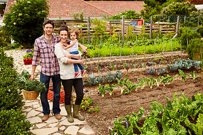 Buy stock photo Portrait of a smiling couple and their little daughter standing in their organic garden