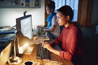 Buy stock photo Shot of a young woman working on a laptop in an office in the evening