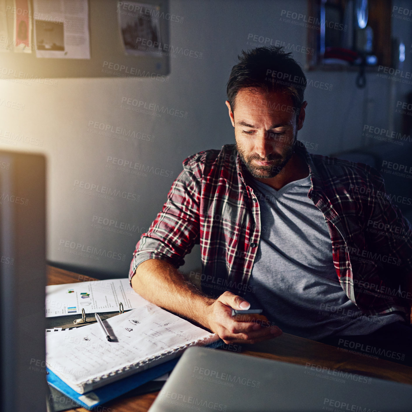 Buy stock photo Night, creative and man with phone in office for graphic design notification, text message or post. Mobile, reading email or person in startup for logo layout, overtime or development progress update