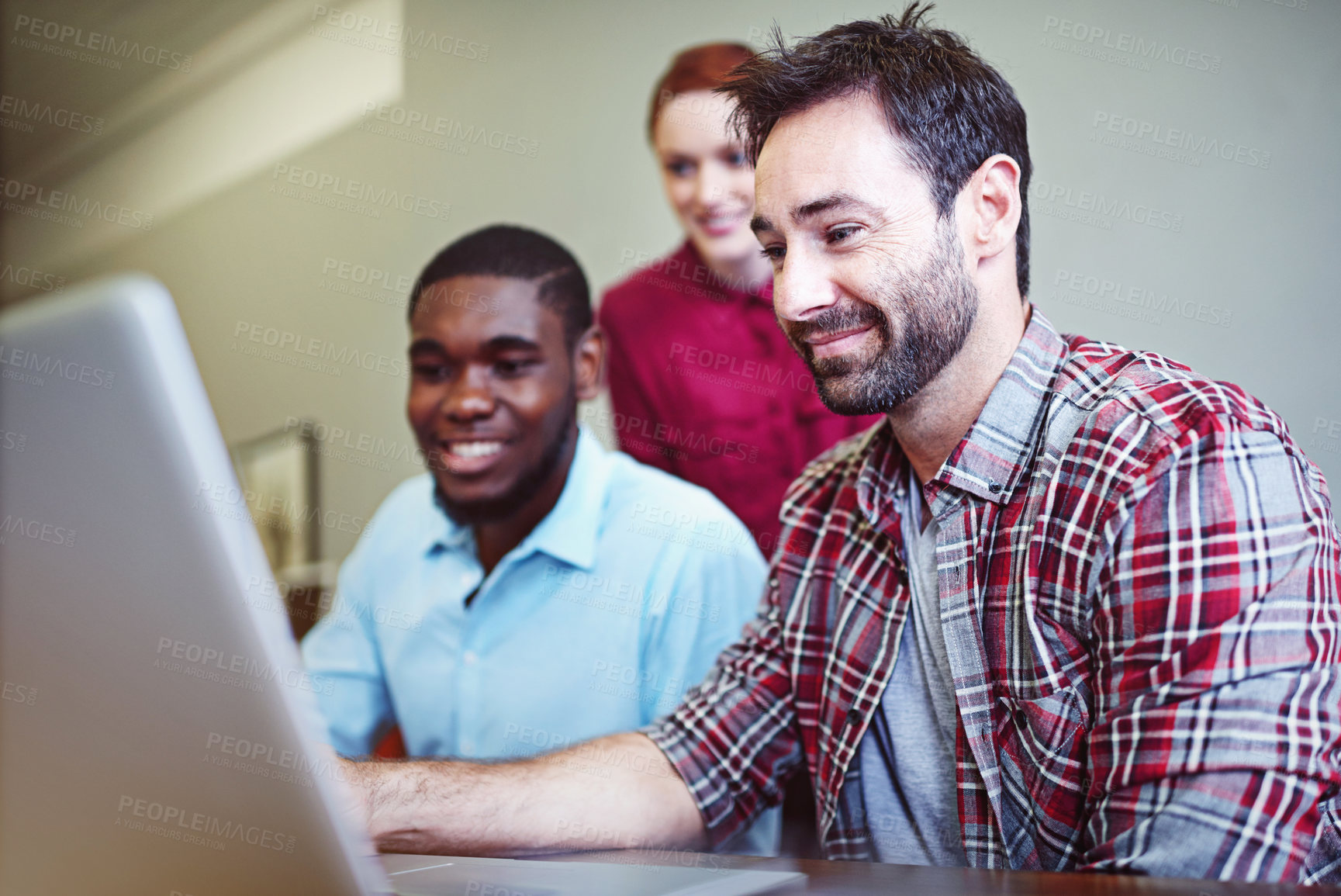 Buy stock photo Shot of a group of businesspeople working together on a laptop in an office