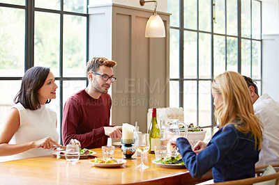 Buy stock photo Shot of a group of friends enjoying a home-cooked dinner together