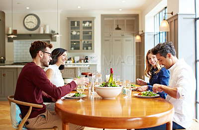 Buy stock photo Shot of a group of friends enjoying a home-cooked dinner together