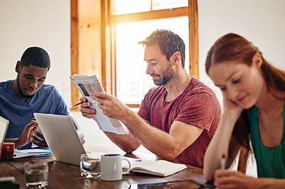 Buy stock photo Shot of a diverse group of colleagues sitting a desk in an office at breaktime