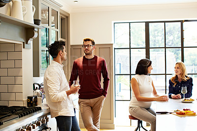 Buy stock photo Shot of two young couples having a chat while chilling in the kitchen