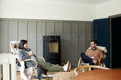 Buy stock photo Shot of a young man and his pregnant wife relaxing in their  living room