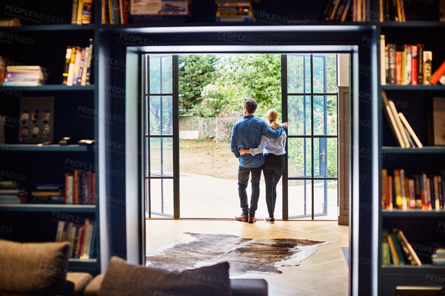 Buy stock photo Door, hug and back of people in home on vacation, getaway or weekend break with bonding together. View, couple and man embracing woman by entrance for connection, care or marriage on holiday at house