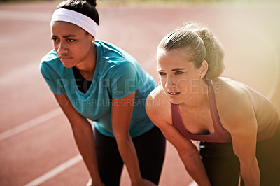 Buy stock photo Shot of two young athletes looking tired after a run on the track