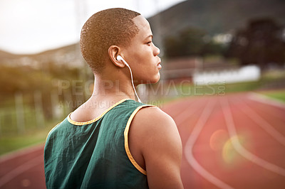 Buy stock photo Cropped shot of a young athlete listening to music while out on the track
