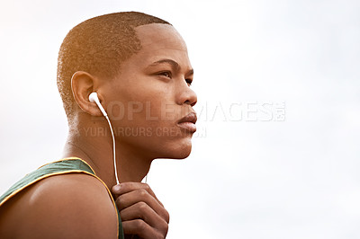 Buy stock photo Cropped shot of a young athlete listening to music while out on the track