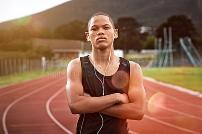 Buy stock photo Cropped shot of a young athlete listening to music while out on the track