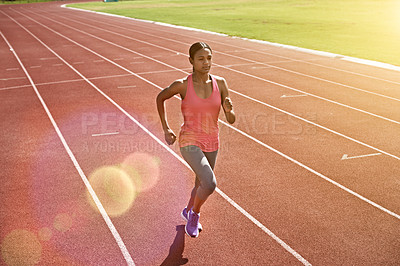 Buy stock photo Shot of a young athlete out running on the track
