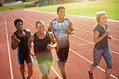 Buy stock photo Shot of a group of young athletes out running on the track