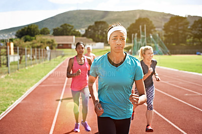 Buy stock photo Shot of a group of young athletes out running on the track