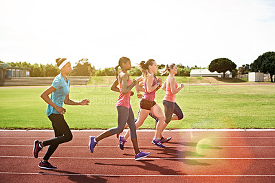 Buy stock photo Shot of a group of young athletes out running on the track