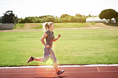 Buy stock photo Shot of a young athlete out running on the track