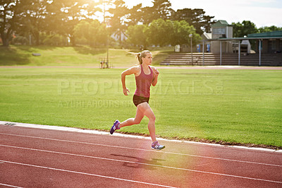 Buy stock photo Shot of a young athlete out running on the track