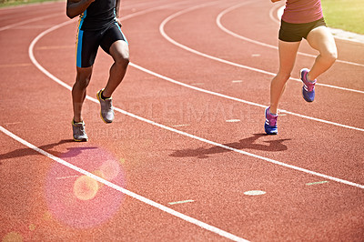 Buy stock photo Shot of two unrecognizable athletes racing on the track