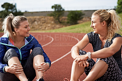 Buy stock photo Shot of young athletes sitting together on the track