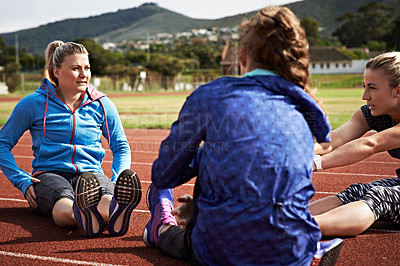 Buy stock photo Shot of young athletes out stretching on the track