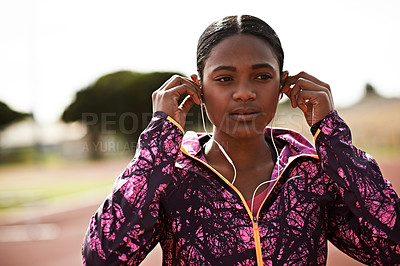 Buy stock photo Cropped shot of a young athlete listening to music while out on the track