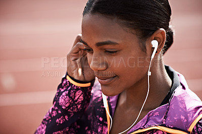 Buy stock photo Cropped shot of a young athlete listening to music while out on the track