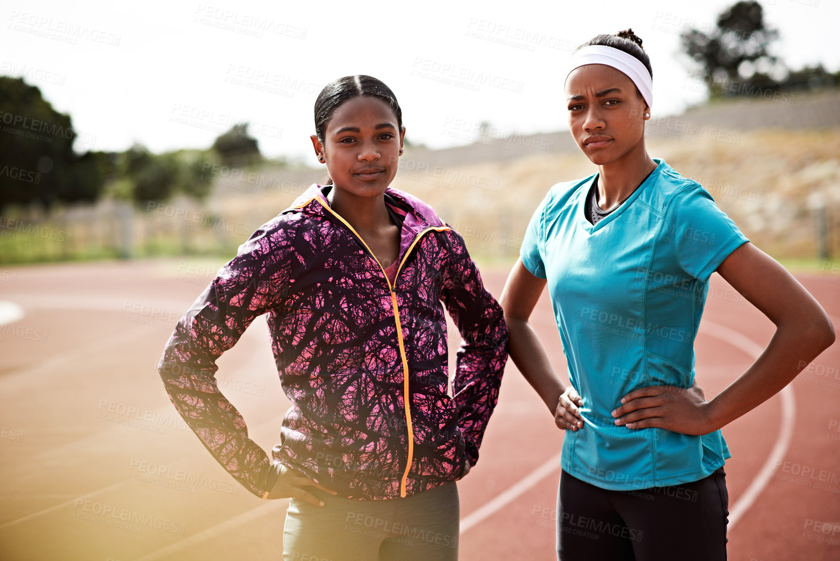 Buy stock photo Cropped shot of two young athletes out on the track