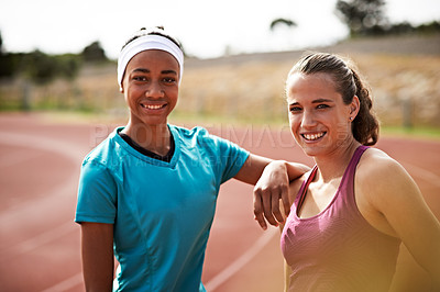Buy stock photo Cropped shot of two young athletes out on the track