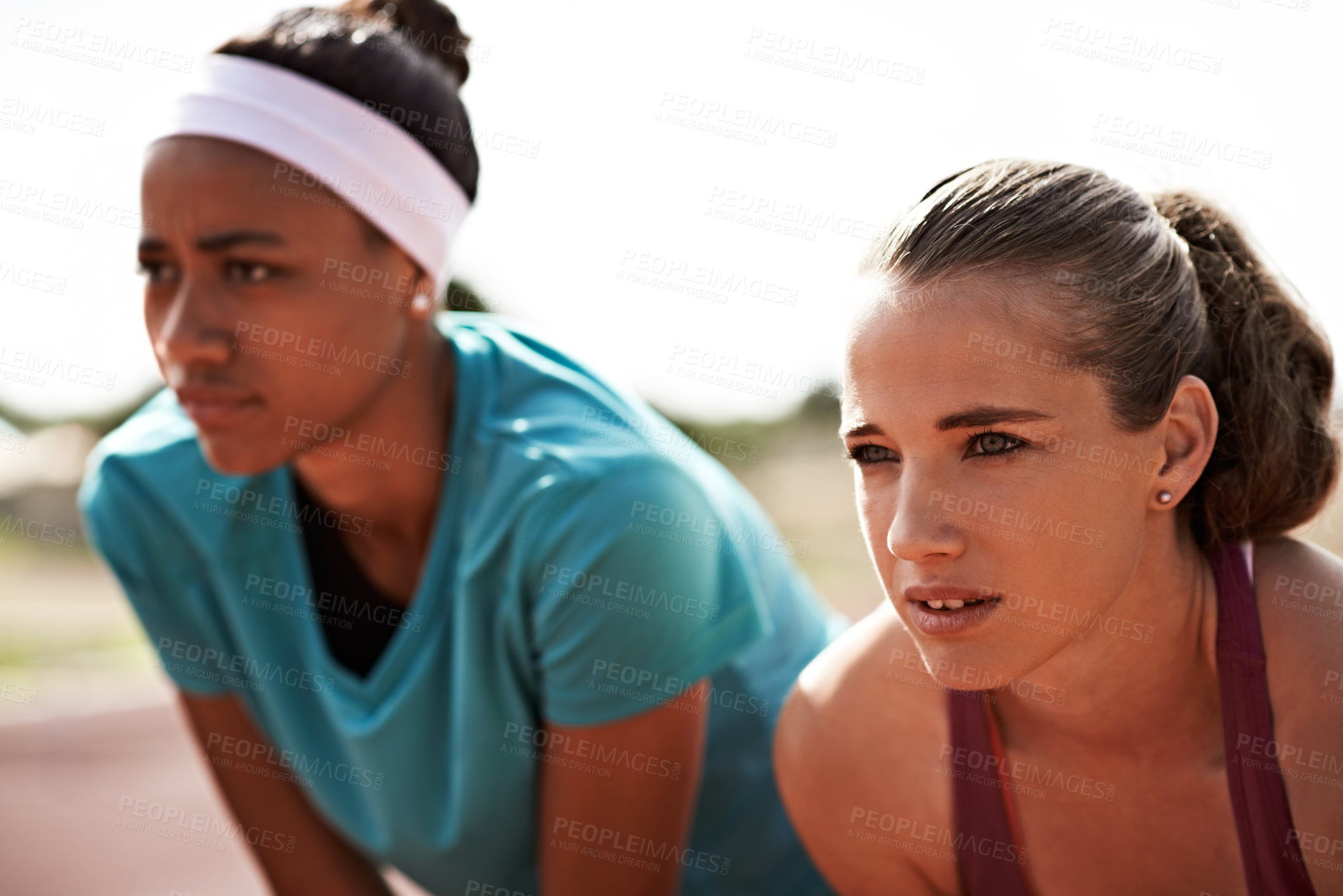 Buy stock photo Cropped shot of two young athletes out on the track
