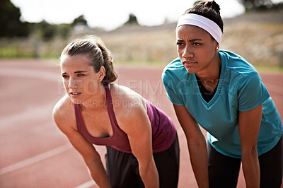Buy stock photo Cropped shot of two young athletes out on the track