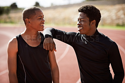 Buy stock photo Cropped shot of two young athletes out on the track