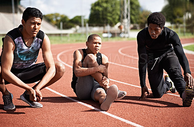 Buy stock photo Shot of young athletes sitting together on the track